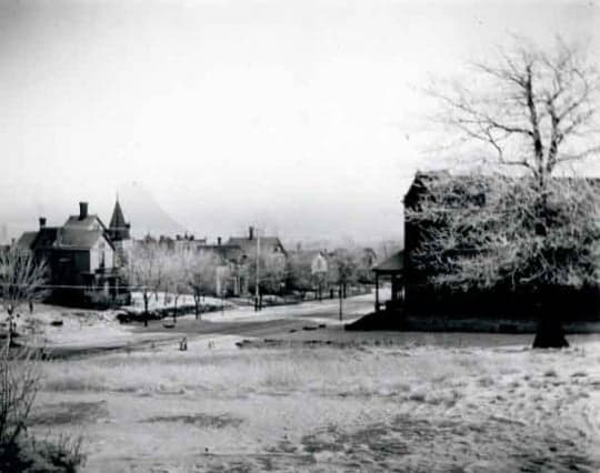 Black-and-white view of Rondo Avenue around 1900, with houses, bare trees, a road and open foreground.