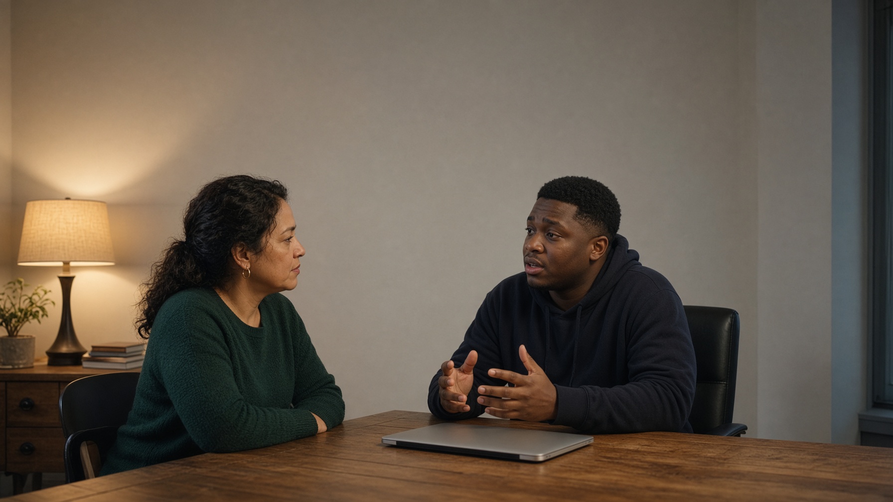 A staff person listens while a young man explains who he wants at his meeting.