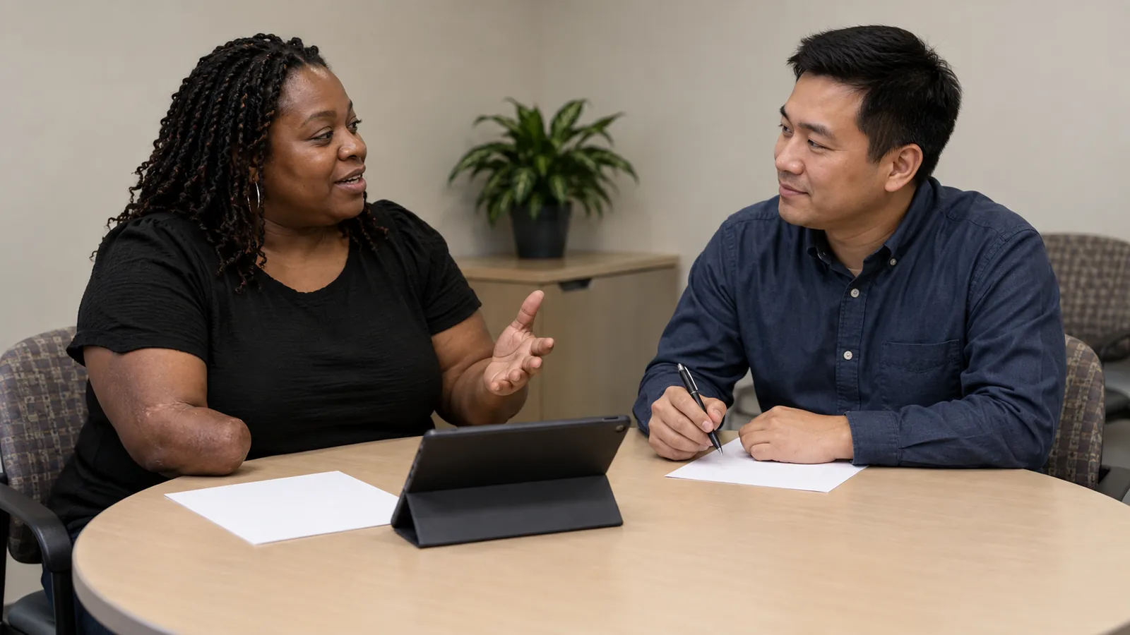 A navigator and visitor discuss personal goals at a worktable.
