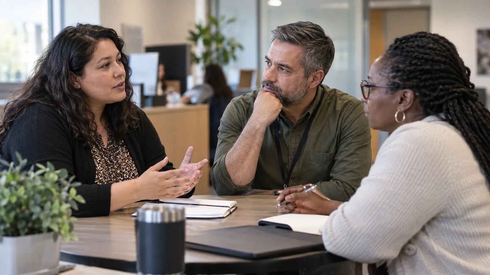 Colleagues listen to one another during a small workplace conversation.