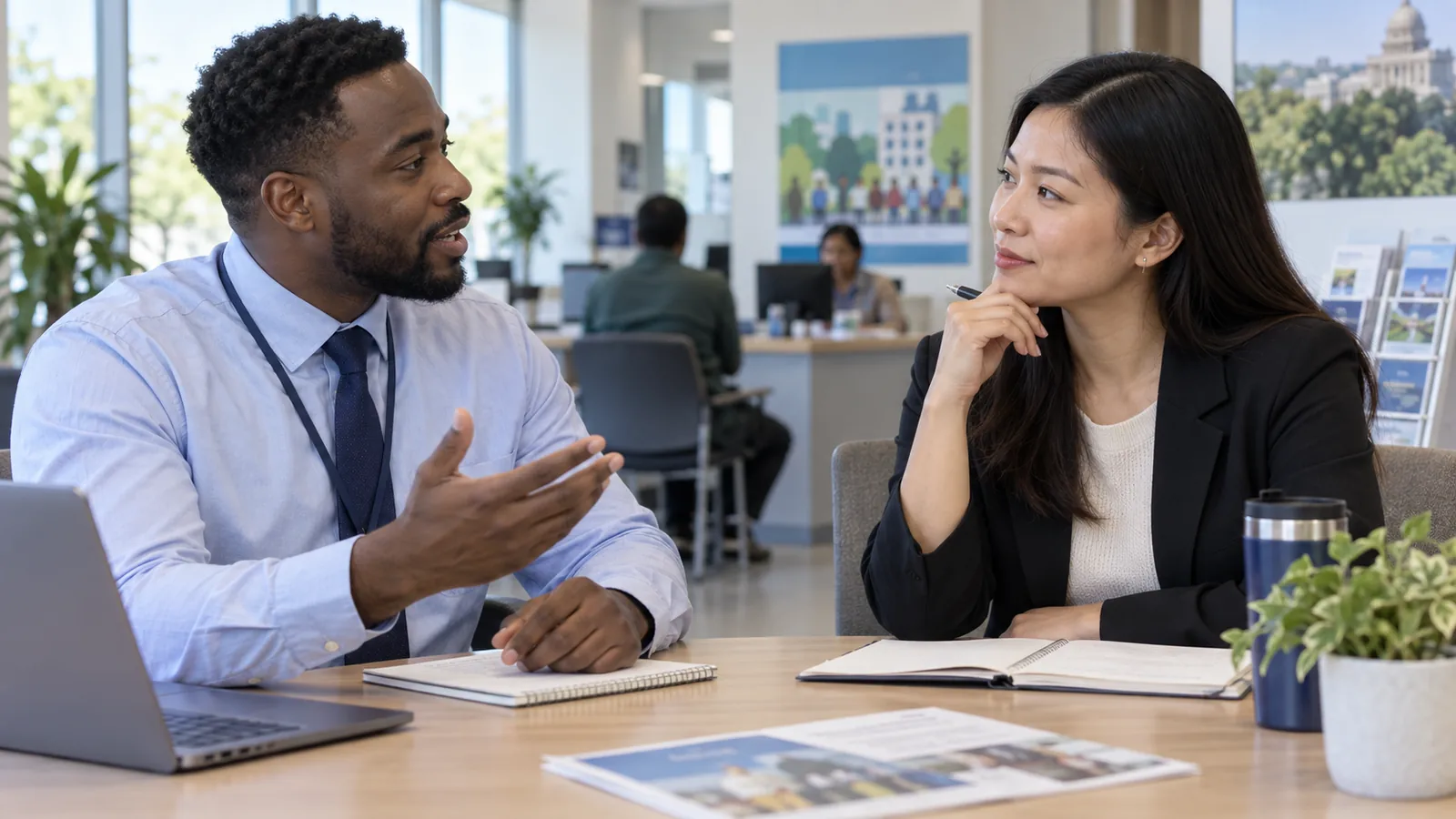 One colleague speaks while another listens closely across a table.