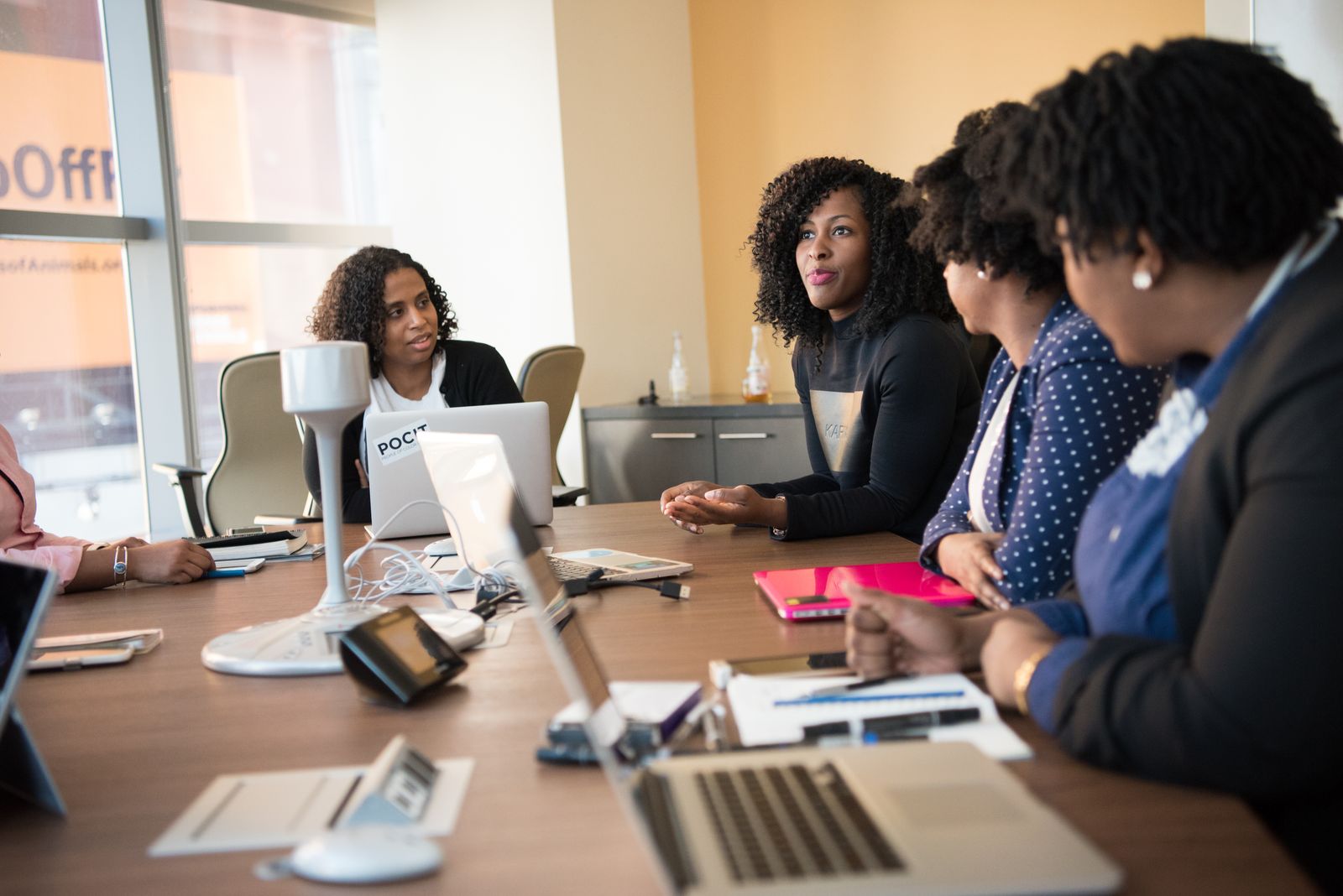 Colleagues meeting around a table, including a colleague using a wheelchair.