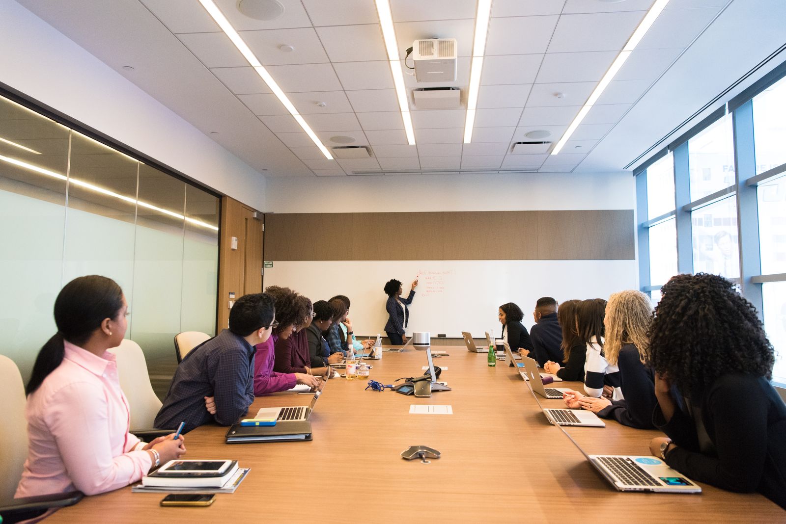 A colleague presents an idea to two others gathered around a table.