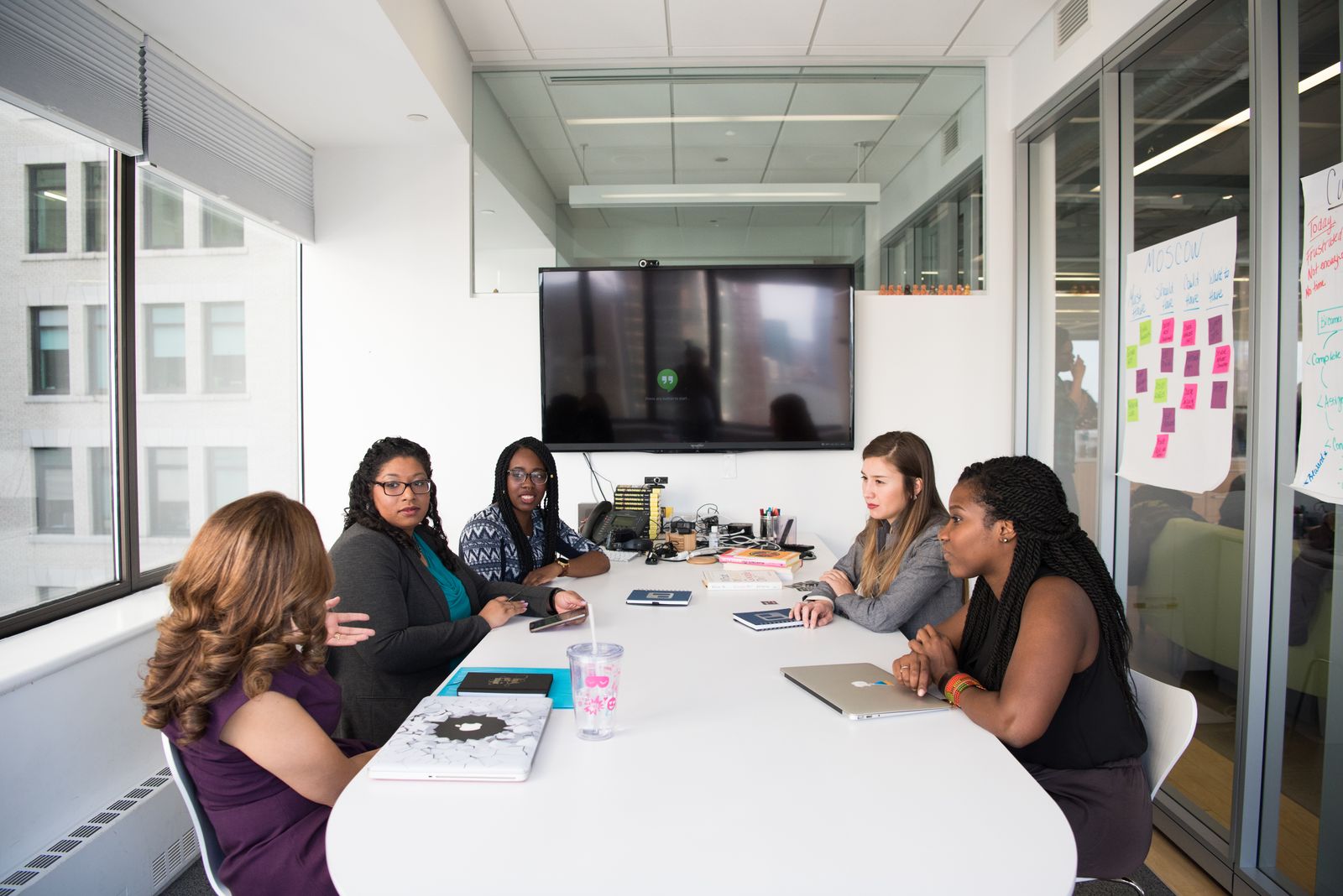 Four colleagues talking together in a bright office space.