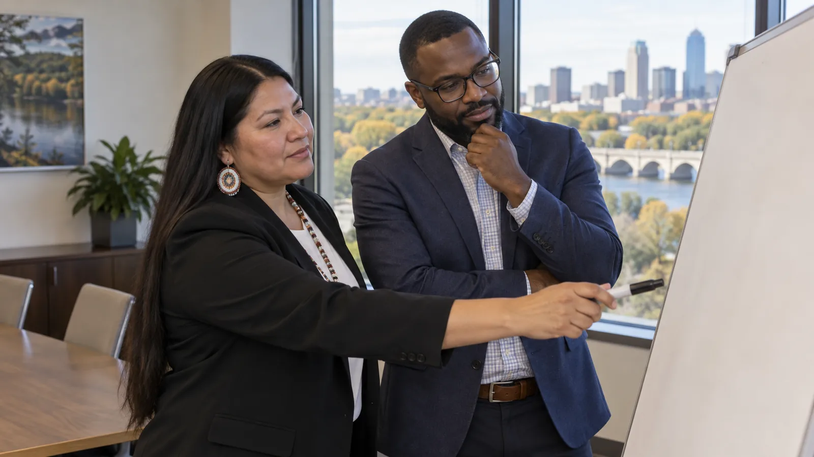 A Native professional and a colleague discuss a planning board together.